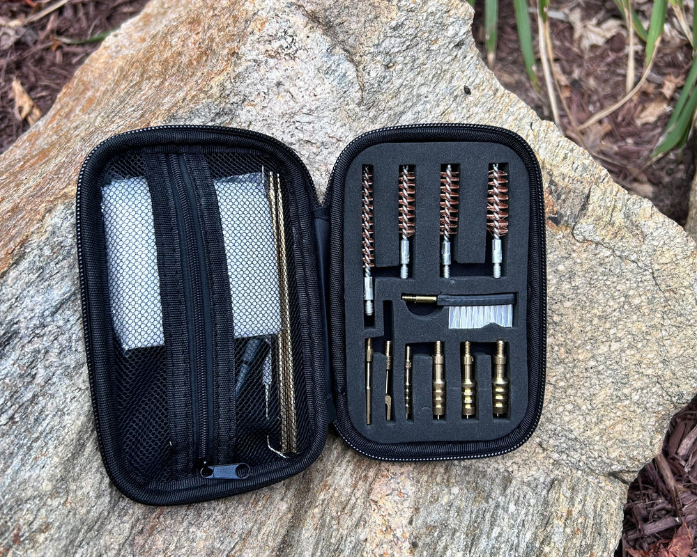 Riptide Gun Cleaning Bundle contents displayed in a compact case on a rocky surface.